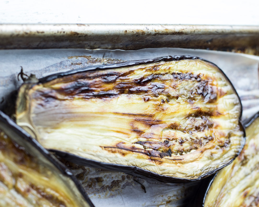 Roasted Eggplant on a sheet pan showing the roasted side