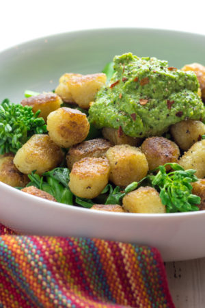 cauliflower gnocchi in a bowl with pesto and veggies