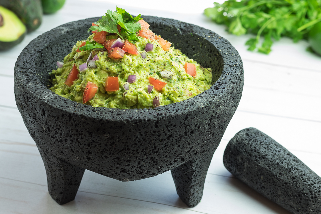 Guacamole piled high in a stone malcajete