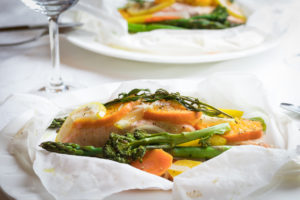 Salmon in parchment paper plated with veggies