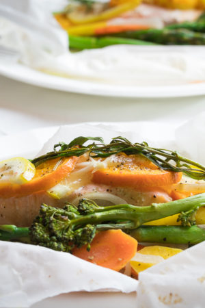 Salmon in parchment paper plated with veggies