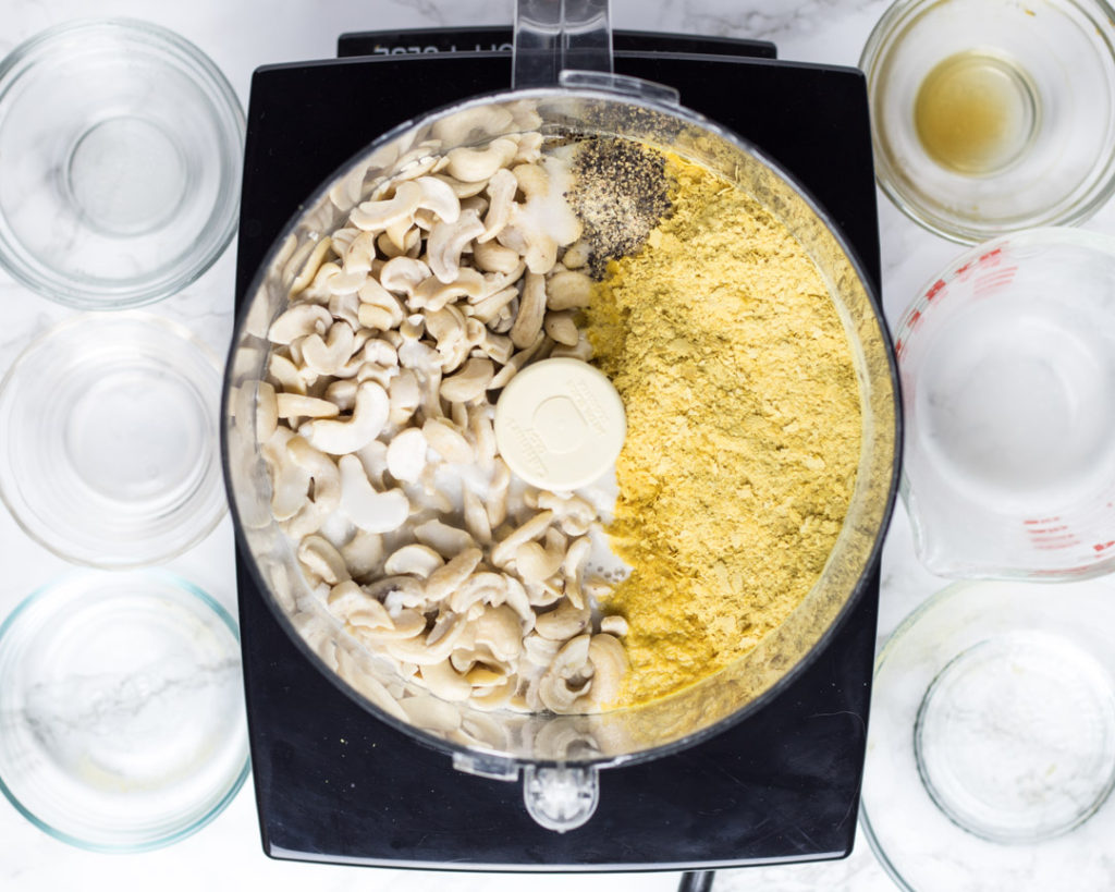 Ingredients for cashew Alfredo sauce in a food processor bowl...