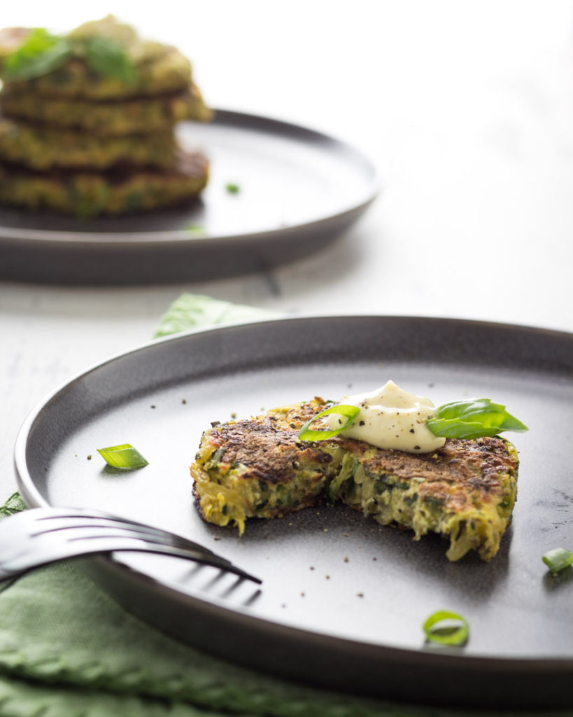 Zucchini and potato pancake on a plate with a bite taken out