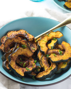 Spice roasted acorn squash in a light blue bowl