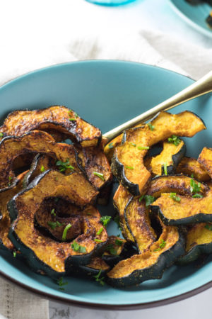 Spice roasted acorn squash in a light blue bowl